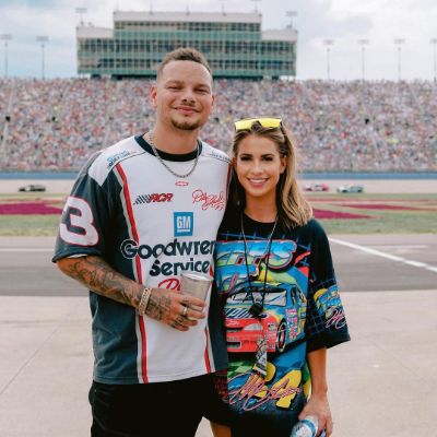 She is wearing Disney's Cars shirt while Kane is wearing Jeff's racing jersey.